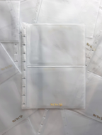 Clear plastic pages with gold text on a white background