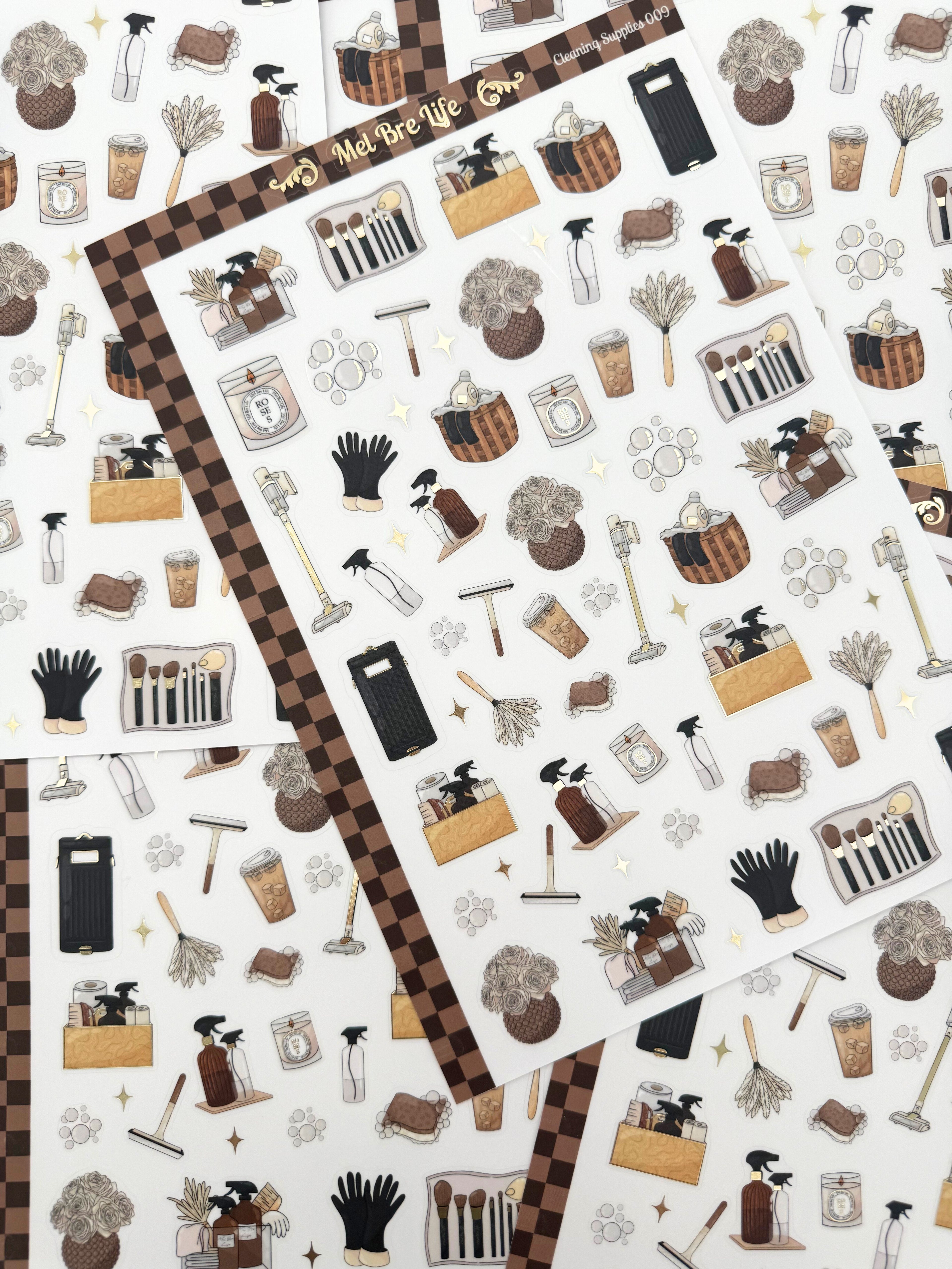 Clear matte glam planner sticker sheet with gold foil accents featuring cleaning supplies, baskets, sprays, and cozy home reset icons