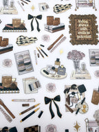 Clear matte glam planner sticker sheet with gold foil accents featuring lifestyle icons, home décor, beauty details, florals, and planning supplies