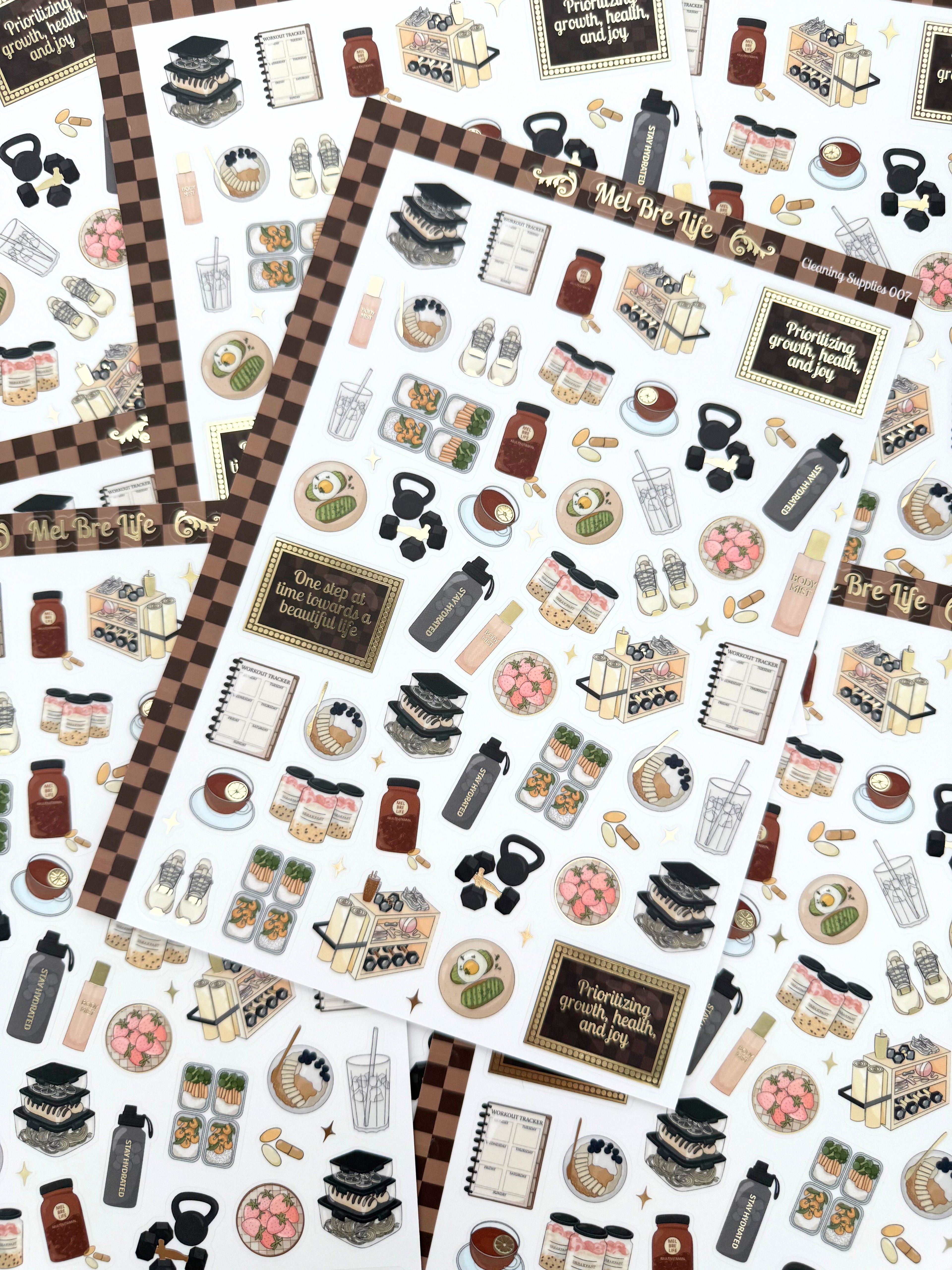 Clear matte glam planner sticker sheet with gold foil accents featuring wellness icons, workouts, meals, drinks, and habit tracking details