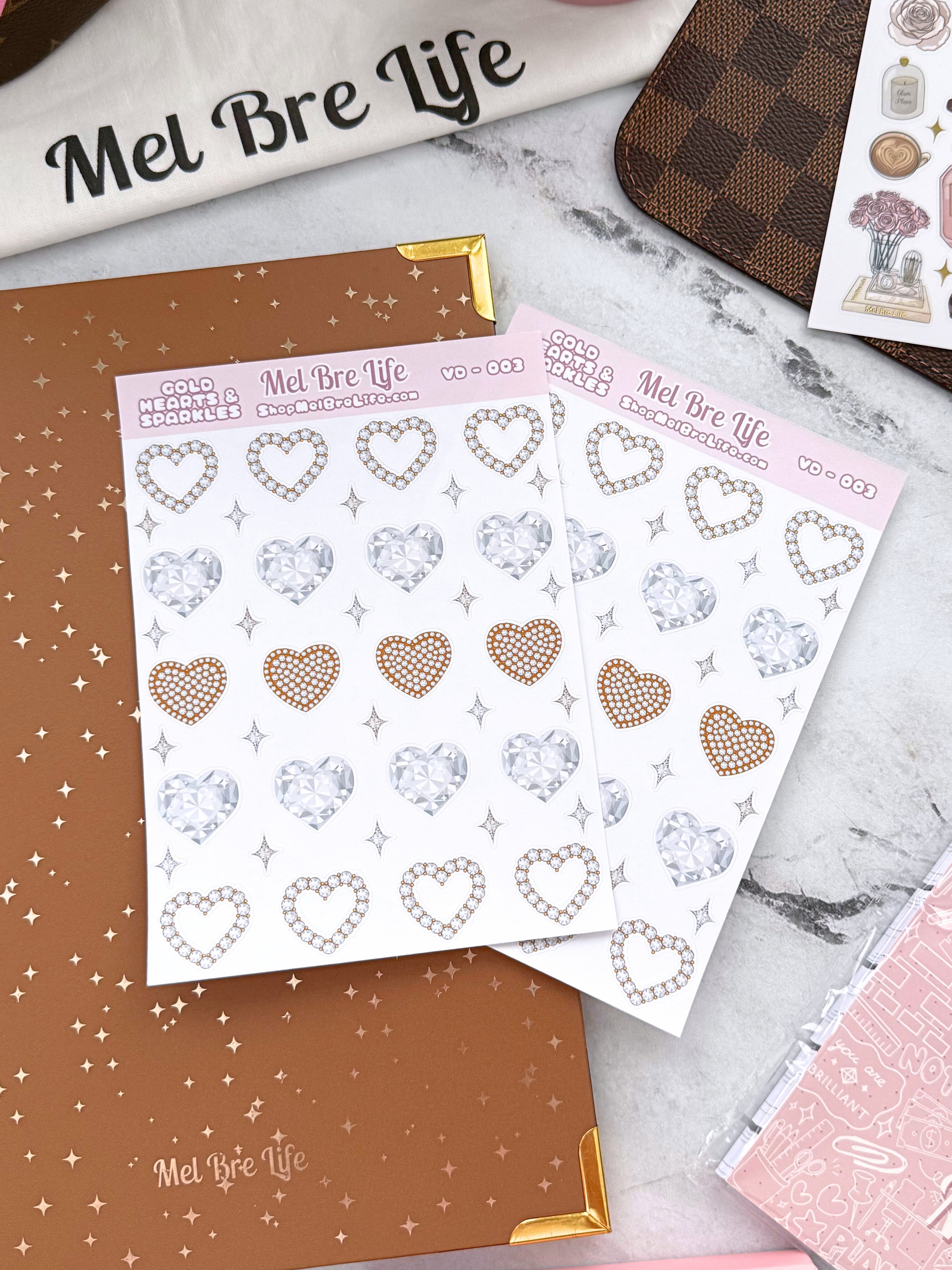 Sheets of decorative heart stickers with 'Mel Bre Life' branding on a marble surface.