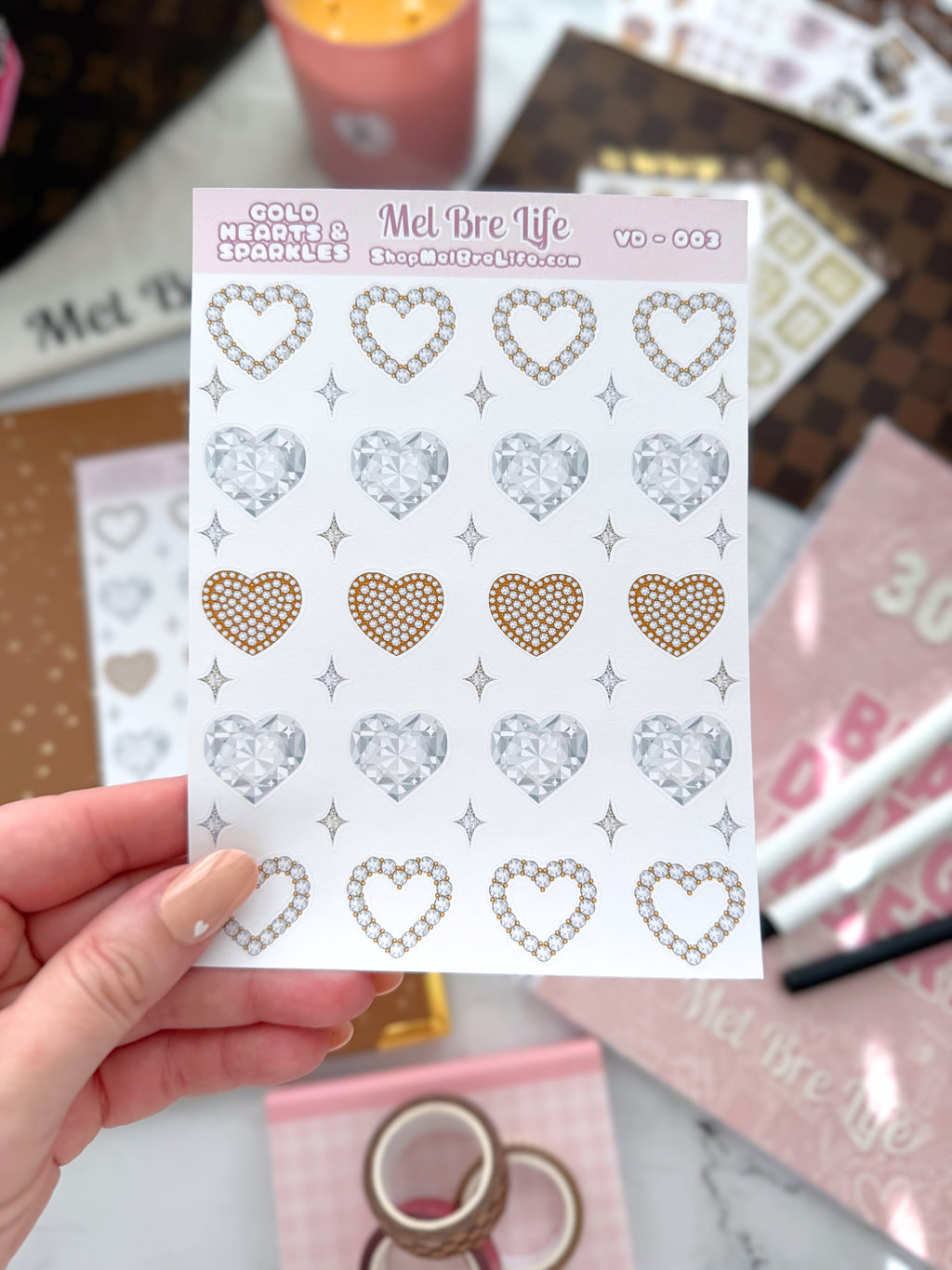 Sheet of decorative heart-shaped stickers held by a hand with a blurred background
