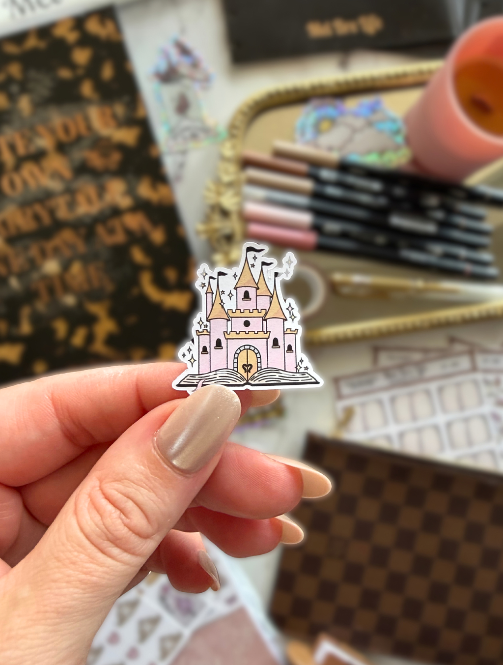 Fairytale Wishes castle sticker featuring a pink and gold fairytale castle on an open book