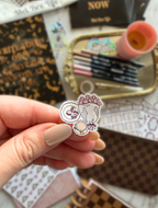 Close-up of a Tea Party sticker featuring a bouquet of pink flowers, macarons, and a teacup
